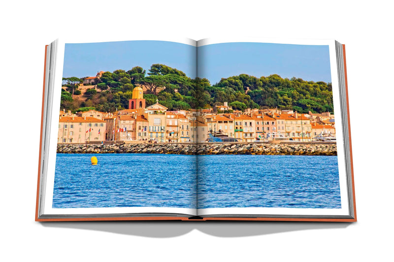 Libro abierto con foto panorámica de ciudad costera y mar azul
