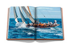 Libro abierto con foto de velero navegando en mar azul