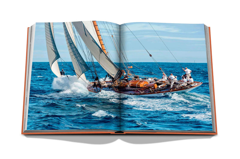 Libro abierto con foto de velero navegando en mar azul