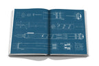 Libro abierto con diagramas técnicos azules y silueta de pluma