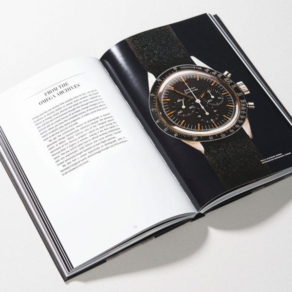 Libro de relojes abierto con foto de reloj negro, esfera naranja y correa oscura