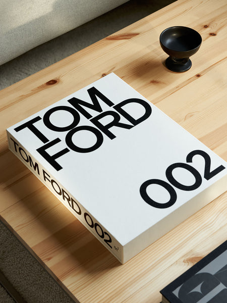 Tom Ford 002: caja de cartón blanca con “002” sobre superficie de madera