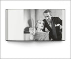 Libro abierto con foto en blanco y negro: hombre con saco y mujer junto a él