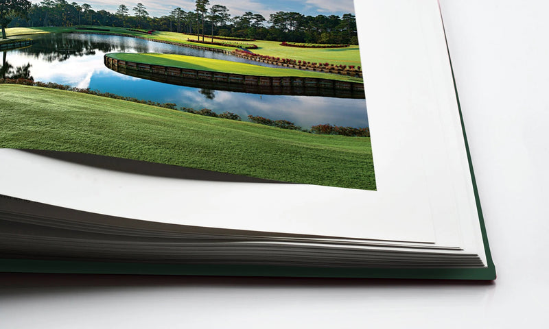 Libro abierto con una foto panorámica de un campo de golf y un lago.