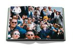 Libro abierto con foto grupal de personas en un evento, varias gafas y sombreros.