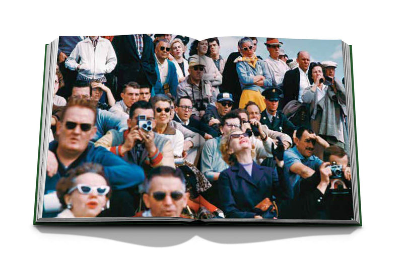 Libro abierto con foto grupal de personas en un evento, varias gafas y sombreros.