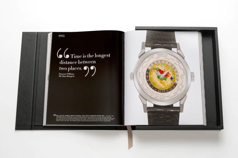 Libro de colección Patek Philippe abierto con reloj plateado de correa gris