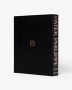 Libro de tapa negra con texto PATEK PHILIPPE en vertical y detalles dorados