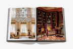 Libro abierto con dos fotos interiores: sala de estar con candelabros y zona de lectura.
