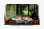 Libro abierto con foto de mesa servida y decoración en comedor con vegetación.