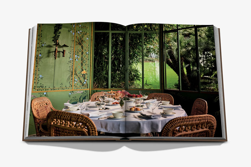 Libro abierto con foto de mesa servida y decoración en comedor con vegetación.
