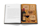 Libro de vino y viajes Francia abierto, a la derecha copa y botella con etiquetas