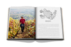 Libro de vino y viajes Francia abierto, caminante en viñedos y mapa de Borgoña