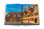 Libro de vino y viajes Francia abierto, patio con edificios de tejados de colores