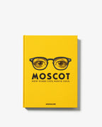 Libro de tapa amarilla con gafas ilustradas y texto MOSCOT en la portada