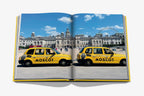 Libro abierto con dos taxis amarillos en calle; escena urbana en doble página