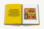 Libro abierto con cita en amarillo y dibujo de tienda iluminada con letrero MOSCOT