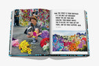 Libro abierto con foto de mujer con flores y mural colorido en doble página.