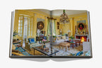Libro Sala de estar abierto: salón clásico con candelabro, cuadros y chimenea.