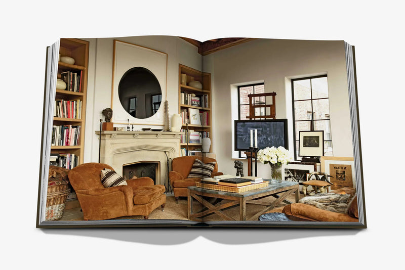 Libro Sala de estar abierto: salón con chimenea, sillón de cuero y estanterías.