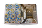 Libro abierto con foto de interior: pasillo de azulejos azules y arcos de piedra.