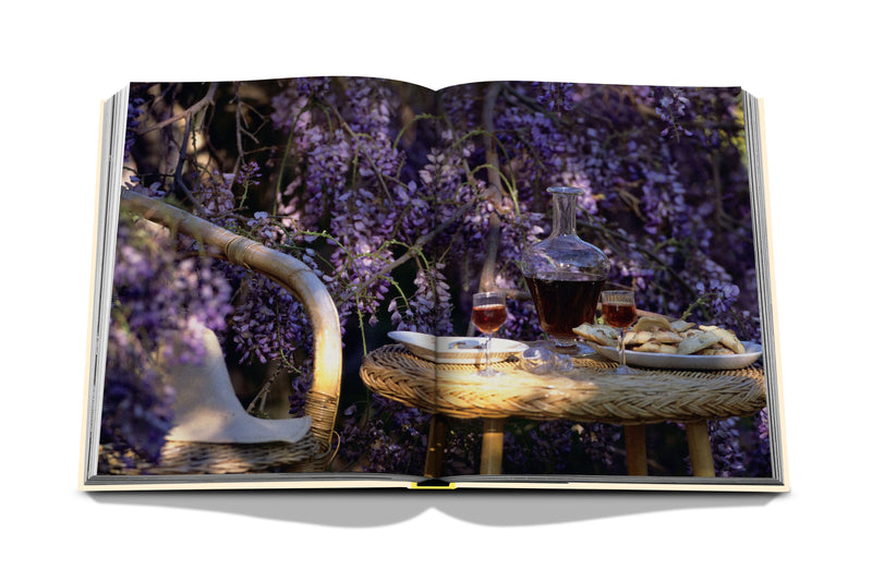 Libro abierto con lavanda morada y mesa con botellas y platos