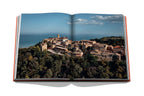 Libro abierto: foto panorámica de un pueblo costero entre árboles y colinas