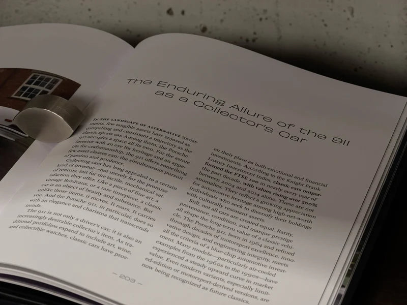 Libro abierto, páginas con texto y título “The Enduring Allure of the 911”