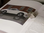 Libro abierto, foto de auto blanco y texto en página interior