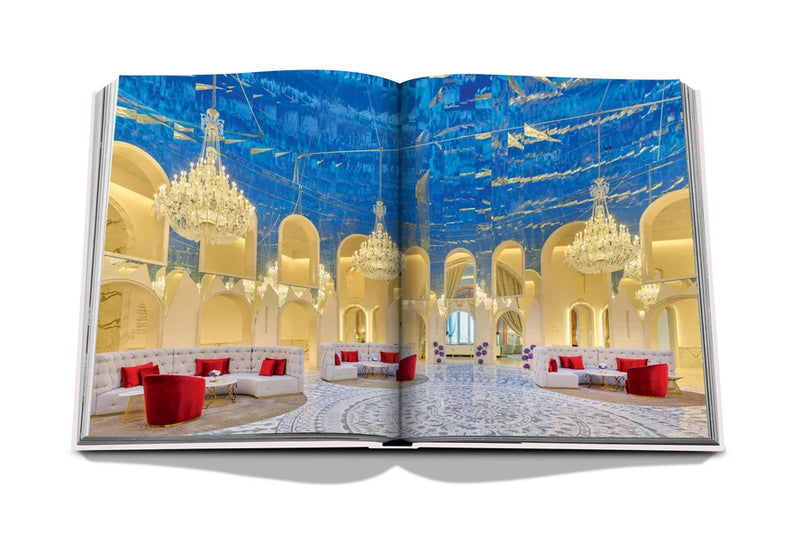 Libro Raffles abierto: salón interior dorado con lámparas y sillas rojas