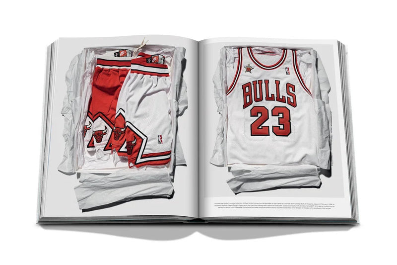 Libro abierto con dos camisetas deportivas blancas con detalles rojos y números