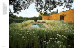 Página de revista con jardín de flores blancas y muro de color ocre al exterior.