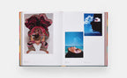 Libro abierto con fotografías de moda: retrato con tocado rojo y escenas sobre fondo azul.