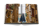 Libro abierto con fotos de calles de piedra y un velero al fondo