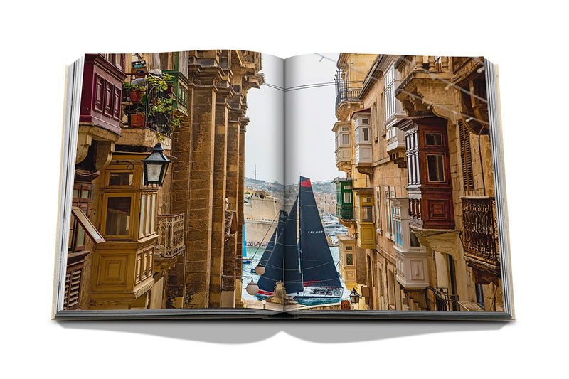 Libro abierto con fotos de calles de piedra y un velero al fondo