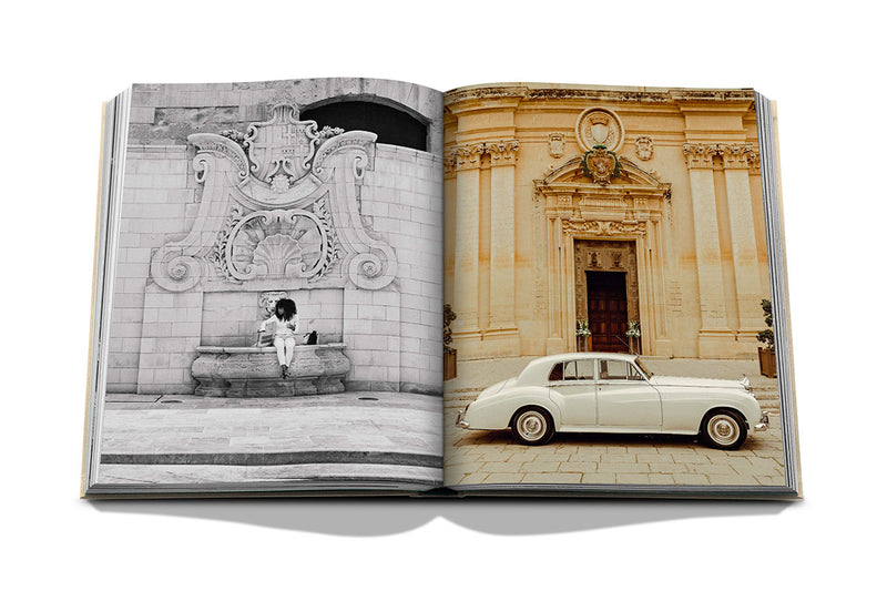 Libro abierto con fotos arquitectónicas y coche clásico en la página derecha