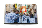 Libro abierto con foto de desfile festivo con espuma y personas