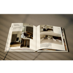 Libro de interiorismo abierto, páginas con fotos de espacios y texto