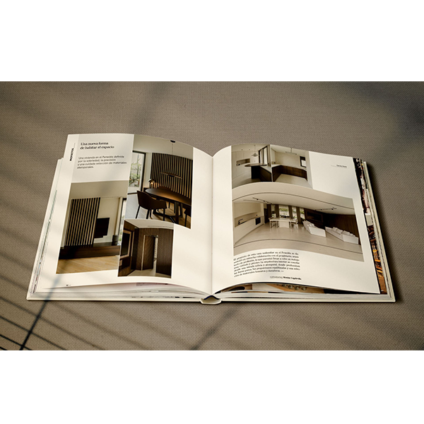 Libro de interiorismo abierto, páginas con fotos de espacios y texto