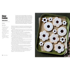 Libro abierto: receta de Linzer Cookies y bandeja de galletas con formas florales.