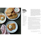 Libro abierto con receta de tortitas de papa y platos con porciones sobre mesa.