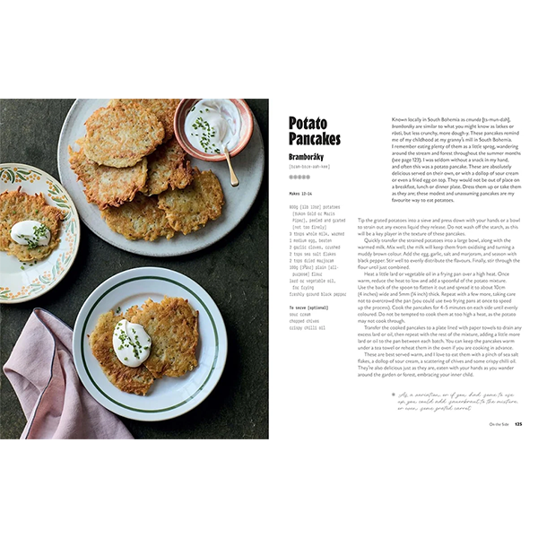 Libro abierto con receta de tortitas de papa y platos con porciones sobre mesa.