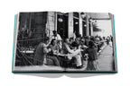 Libro abierto con escena en blanco y negro de personas en una terraza