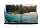 Libro abierto con paisajes costeros y agua turquesa entre montañas