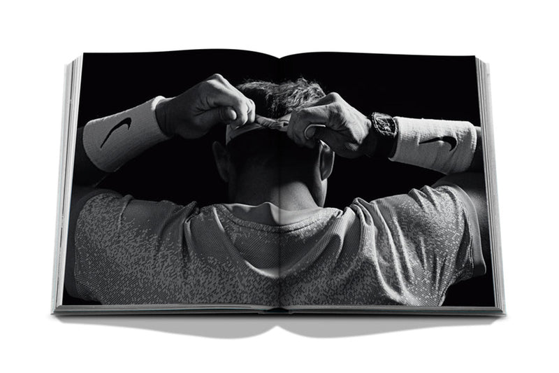 Libro de Assouline abierto, foto en blanco y negro del tenista con puños.
