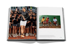 Libro abierto de Assouline con foto grupal de jugadores y escena en cancha.
