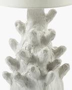 Base decorativa blanca con textura y formas orgánicas, vista detallada de la lámpara