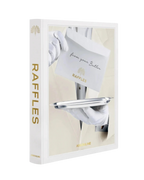 Libro Raffles de Assouline con portada blanca, bandeja metálica y detalle dorado