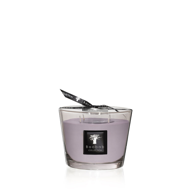 Vela en vaso de vidrio con cera morada y tapita negra con logotipo