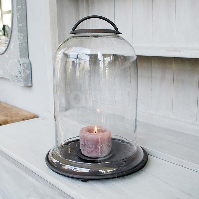 Portavelas de cúpula de vidrio con vela rosa dentro y base negra